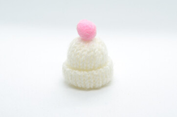 Warm winter white hat with a pink decoration. Minimal concept