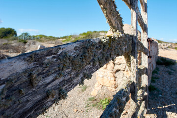 detail of typical wooden door, with lichens, in stone wall next to the road, with beautiful blue...