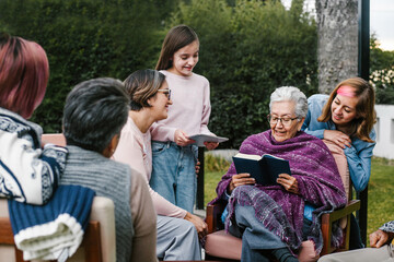 Mexican grandmother and family reading a book in a backyard outside home in Mexico city