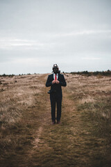 man wearing a gas mask in a field