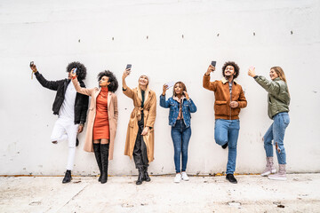 Obraz premium Group of multiracial happy friends with mobile phones, taking selfies.