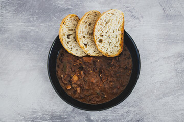 plant-based food, vegan brazilian feijoada with beans and plant-based meats with toasted bread slices