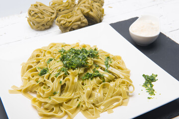 plate of noodles with grated cheese and pesto