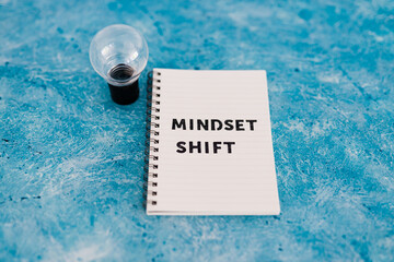 positivity and law of attraction, notepad with Mindset Shift text with light bulb next to it