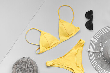 Colors yellow and gray, Color of the year of 2021 Illuminating. Swimming suit with sunglasses bag and hat
