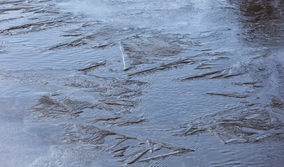 Frozen water background with ice pieces. Natural ice texture with cracks and scratches