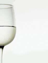 glass of wine half of a wine glass filled with Sparkling white wine on white background