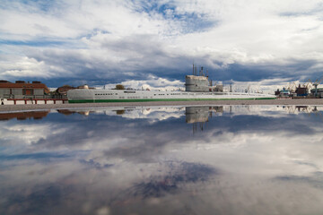 Old soviet submarine in port reflected in puddle