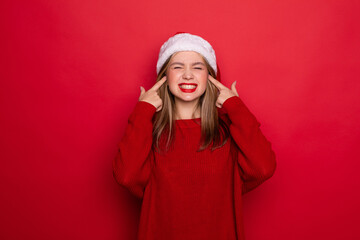 Young woman wearing christmas hat smiling happy pointing with hand and finger on herself on red background
