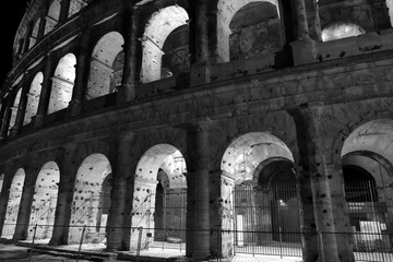 The monuments of rome in black and white at night.	