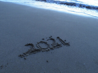 砂浜の波打ち際に書かれた2021の文字