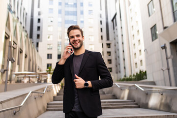 Portrait of a young businessman talking on the phone on the street