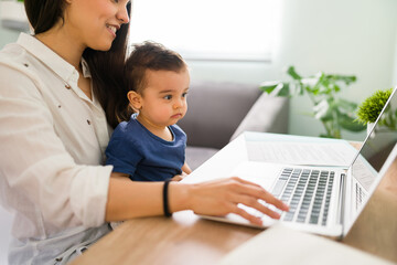 Cute boy with mom working on laptop