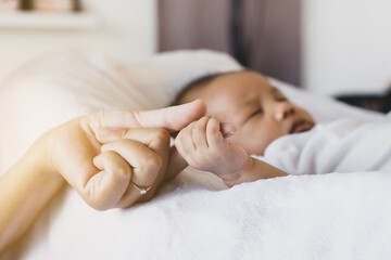 Obraz na płótnie Canvas Close up of hands baby newborn holding mom finger,Family love concept