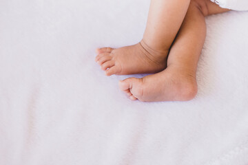 Fototapeta na wymiar Close up of little feet newborn baby lying on a comfortable bed at home
