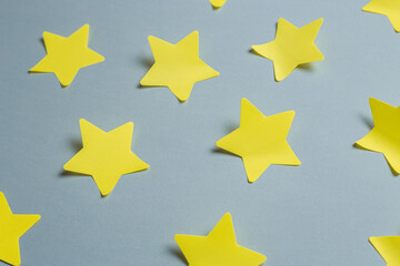 Yellow paper stickers in the form of stars glued on a gray background for text. Minimalistic banner with colors of the year 2021 - Illuminating and Ultimate Gray. - 398375625