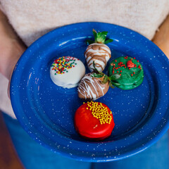 Square picture with blue plate with cookies and strawberry on it