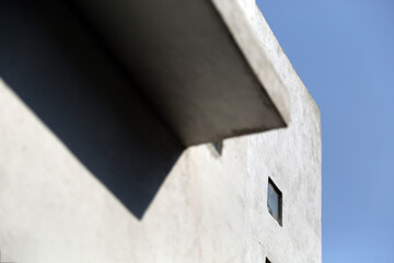 Corner of white building with shadow and blue sky in the back