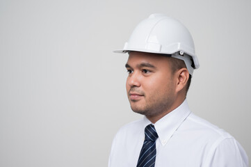Smiling young asian civil engineer wearing helmet hard hat standing on isolated white background. Mechanic service concept.