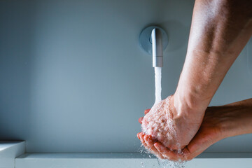 hands washing under the faucet with flowing water