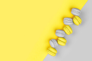 Tasty macarons on yellow - gray background divided diagonally into two triangles