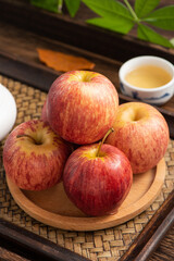 Fresh fruits and small apples on the background of retro Chinese style tea tray