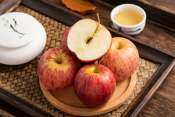 Fresh fruits and small apples on the background of retro Chinese style tea tray