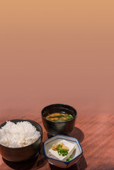 Japanese traditional Tofu knows as a healthy low calories food rich in protein topped with grated ginger and shredded green onions, white rice bowl and a Miso soup consisting of a dashi stock.