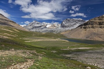 Fototapeta premium Dolomite Pass Green Alpine Meadow and Rugged Mountain Peaks Landscape on Great Hiking Trail in Siffleur Wildernes, Banff National Park, Canadian Rockies