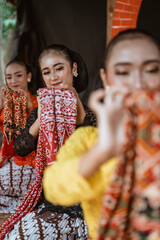 portrait of three young women presenting traditional Javanese dance movements