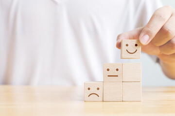 Hand chooses smiley face growth on wood block cube, The best excellent business services rating...