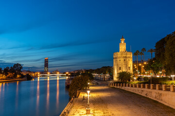 view of seville in spain in blue hour - golden tower and the river guadalquivir