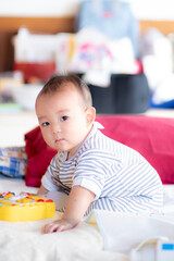 Fototapeta premium Asian infant baby sitting and playin on the bed after wake up in the morning