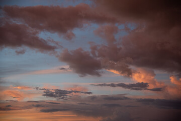 Beautiful sky background. Light blue sky with dramatic orange, pink and gray clouds. Perfect for sky replacement. High quality photo