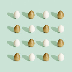 Decorated Easter golden and white eggs on green background.