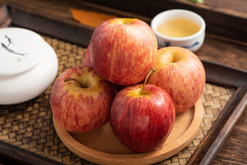 Fresh fruits and small apples on the background of retro Chinese style tea tray