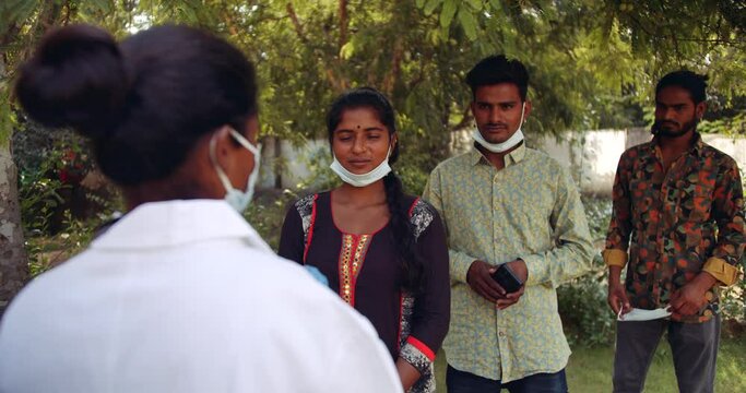 Slow-motion static shot of people standing using smart phone video photo camera mobile phone to record a female doctor, ordering them to wear mask, talks about hand sanitizer washing disinfectant 