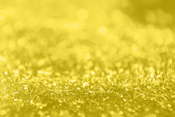 Obraz premium shining textured background in illuminating yellow color. color of the year 2021. glitter festive macro texture. selective focus. 