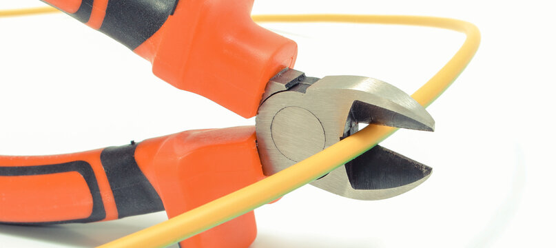 Metal pliers cut electric cable on white background. Technology concept
