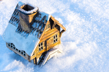 Cute toy house on a snow background. Holiday concept for Christmas, New Year, and sweet home with copy space