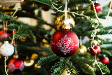 Artificial Christmas Tree with red and gold ornaments and Christmas decoration balls with pattern.