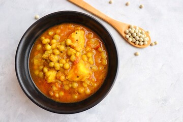 Indian popular homemade Aloo Matar. Potatoes and peas curry. Vatana batata bhaji or sabzi. with cooking ingredients along with copy space.