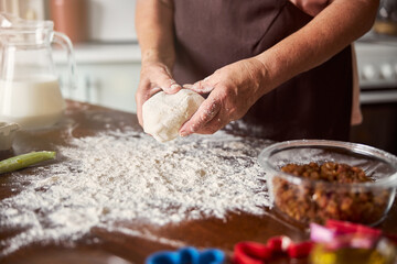 Obraz na płótnie Canvas Experienced baker with a bulky piece of dough in hands
