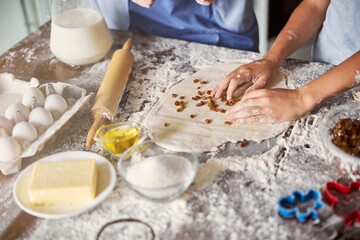 Cooking enthusiasts makiing dough with raisins for cookies