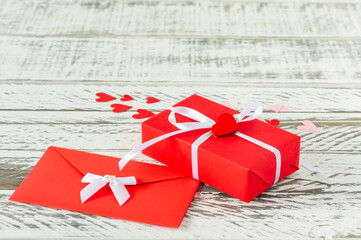 Valentines Day gift box with envelope with love letter, paper hearts on wooden background. greeting...