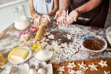 Chef and sous-chef making gingerbread men out of dough