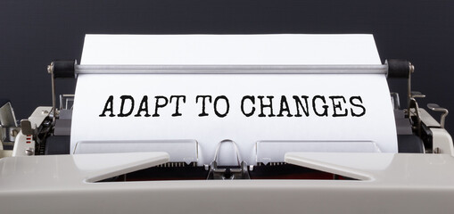 Text ADAPT TO CHANGES, typed on typewriter, close up. Motivational Business Concept.