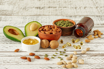 vegetable sources of omega-3 acids. Balanced diet concept. Avocado, nuts, oils on wooden background