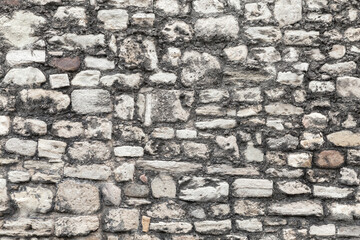 Old grungy dark gray stone wall, front view, texture