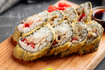Closeup on roasted tempura sushi rolls with chicken and tomato